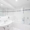 Zur Ausstattung des Bades der Suite Meerseite gehört eine Badewanne, Doppelwaschbecken und Kosmetikspiegel.